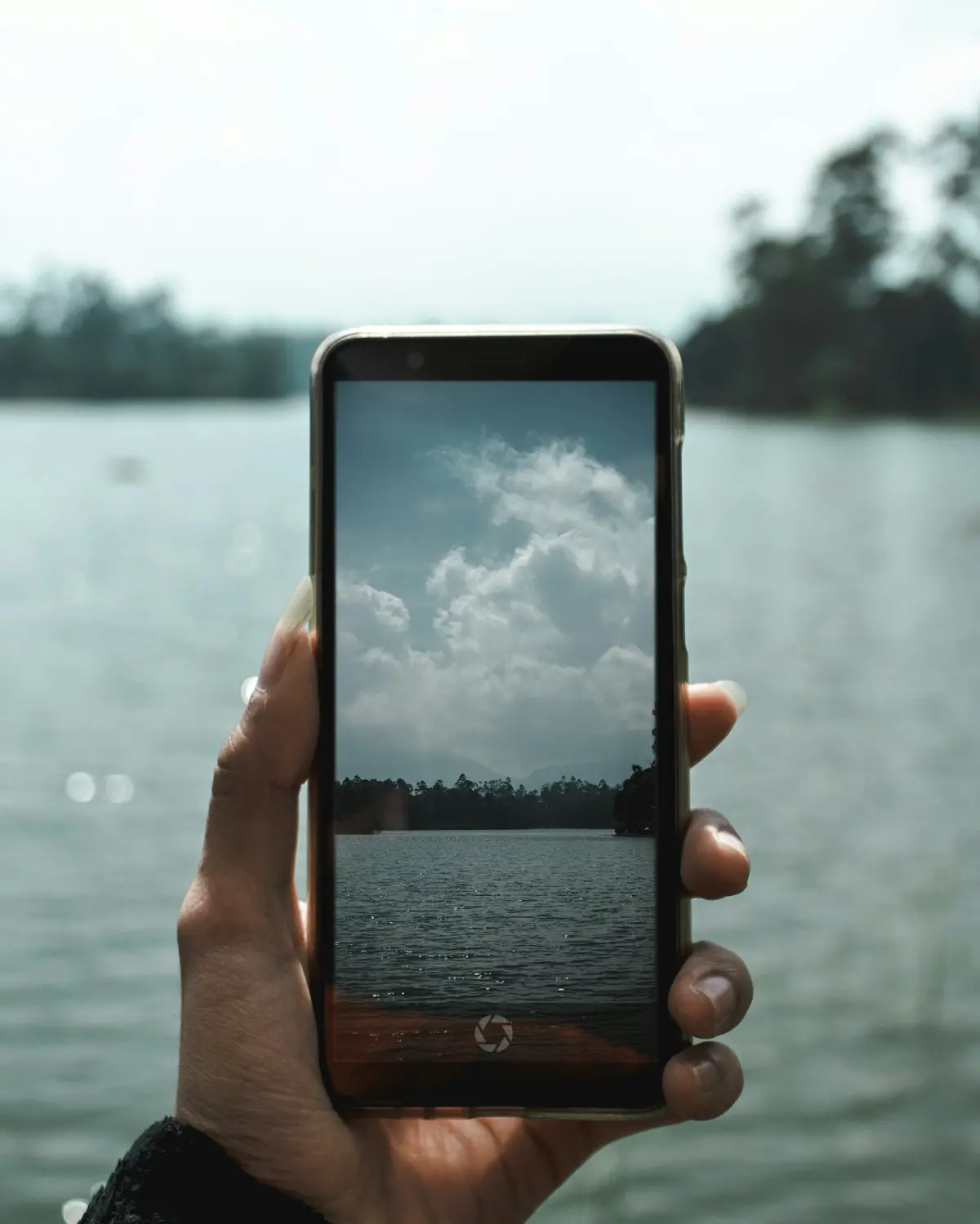 Hand holding an Android smartphone with the camera app open