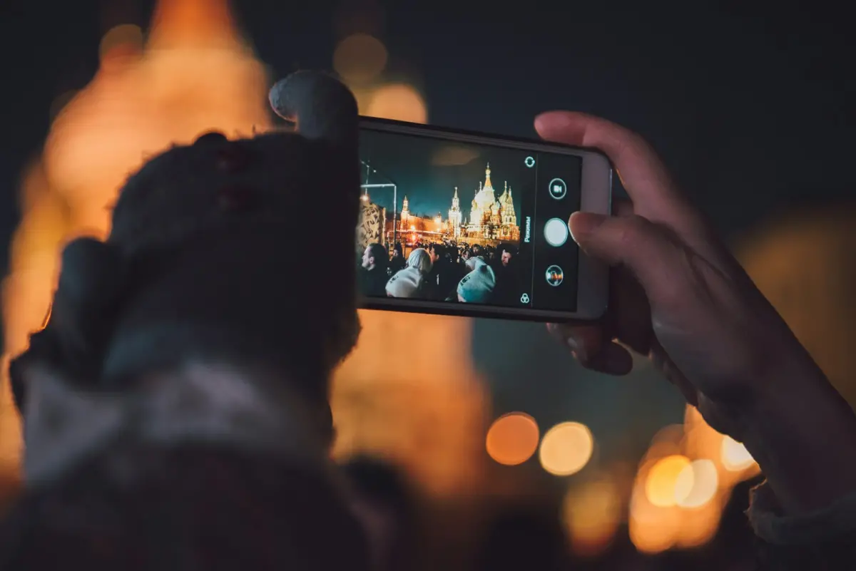 Phone photographing an illuminated building at night