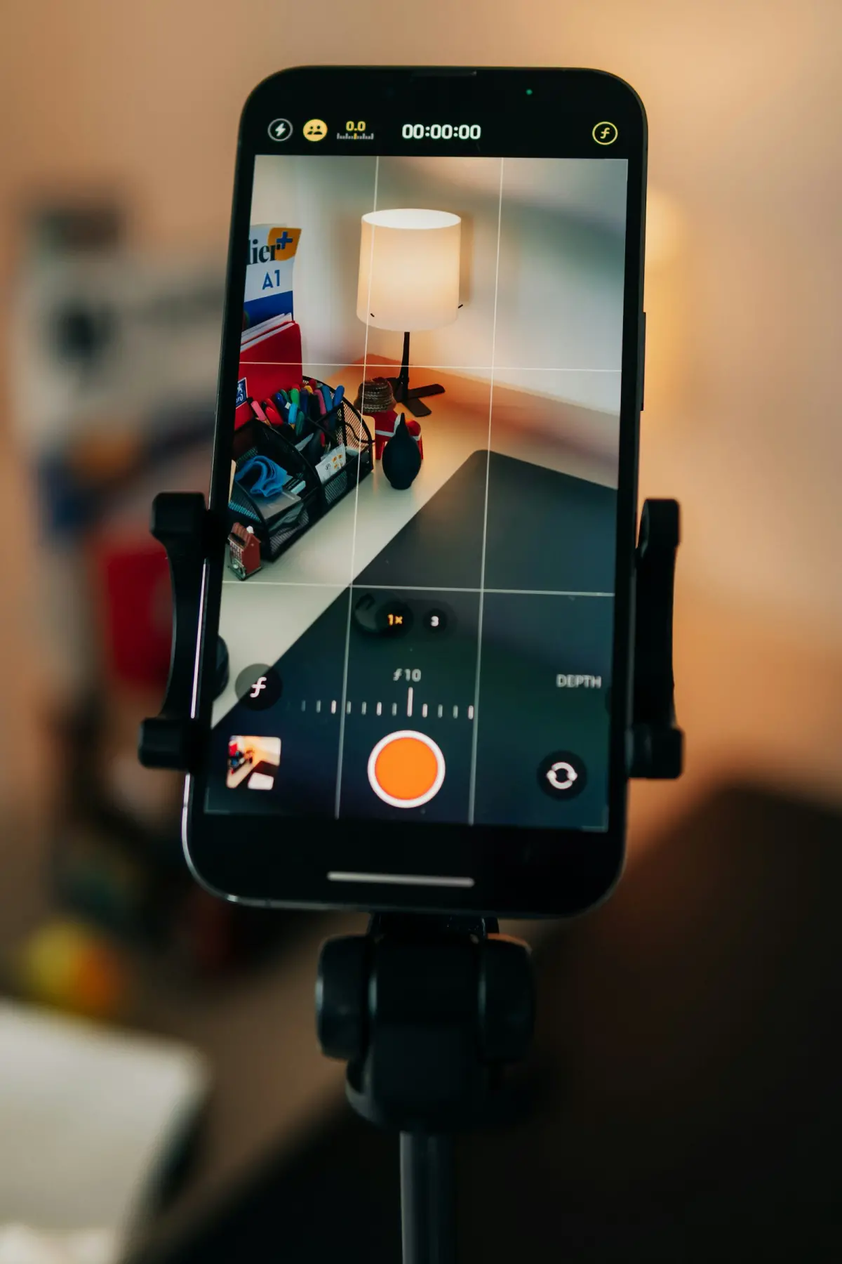 Smartphone on a tripod mount showing a camera app with manual controls