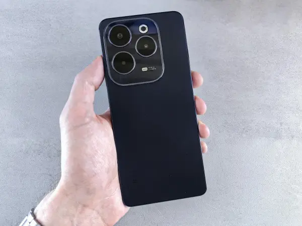 Hand holding a black Android phone showing its rear cameras